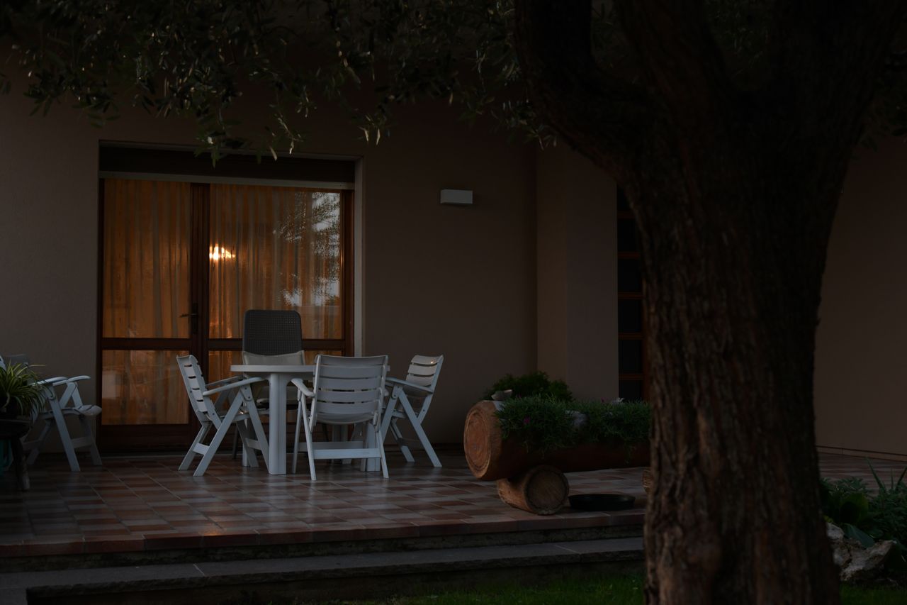 %titre de l'article% Terrasse et jardin mis en valeur par un éclairage extérieur chaleureux le soir