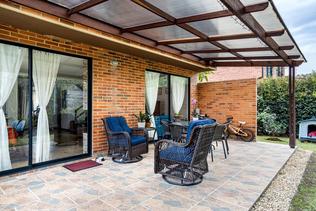 %titre de l'article% Terrasse couverte attenante à une maison, protégée par une pergola