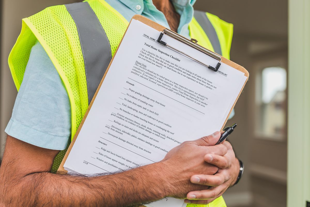 %titre de l'article% Un certificateur relève les caractéristiques d'un logement lors de la visite pour le certificat PEB