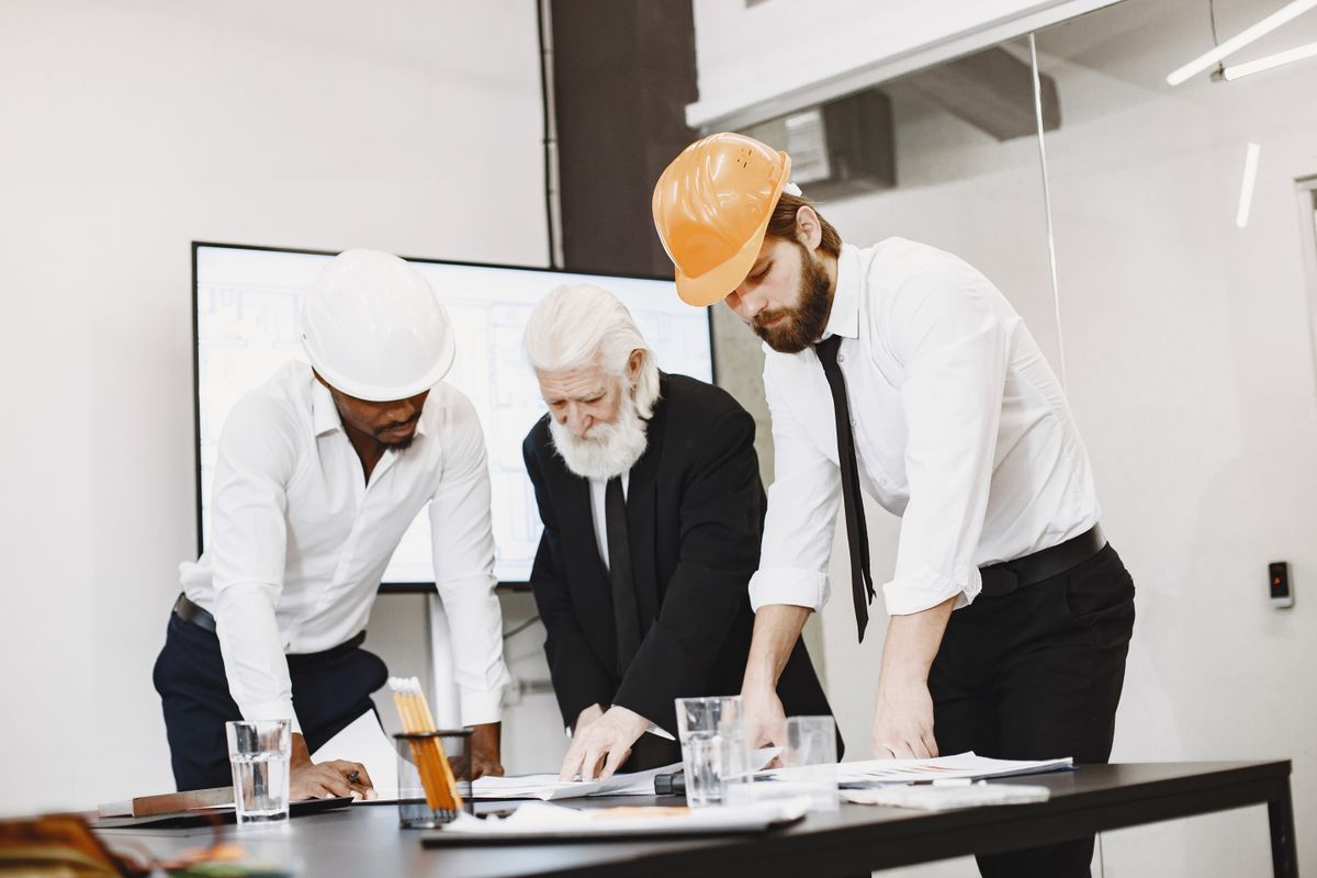 %titre de l'article% Une équipe de professionnels de la construction réunie autour des plans d'un projet
